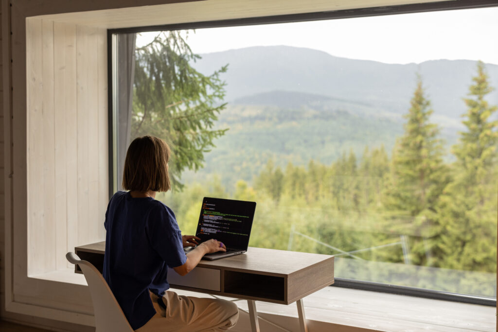 Woman Works On Laptop for Remote Job In House On Nature