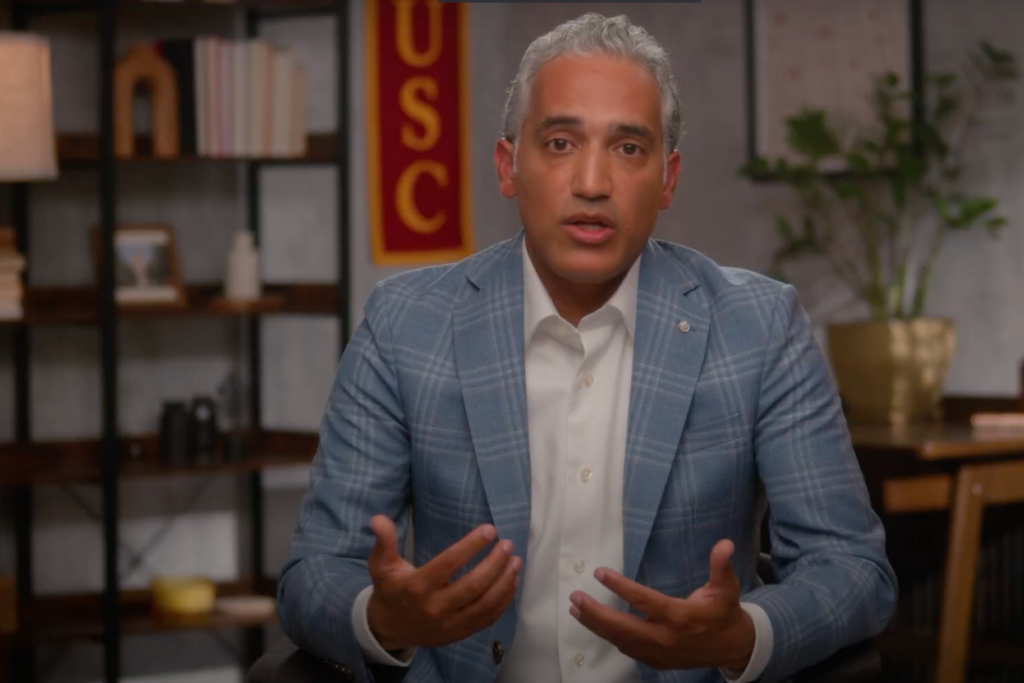 USC Professor in suit gestures with his hands while speaking.