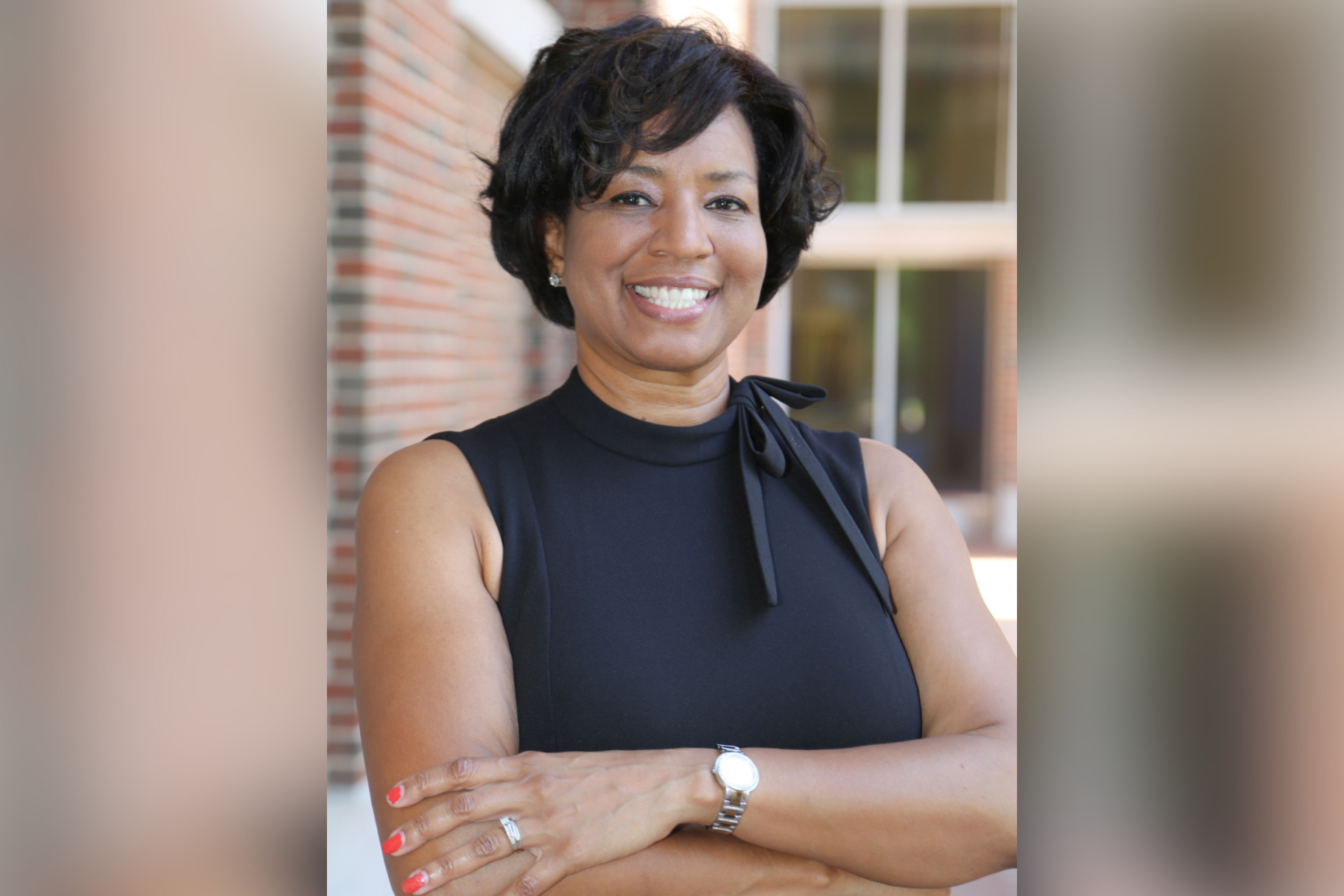 Read about: A headshot of Tammy Samuels smiling at the camera with arms crossed.