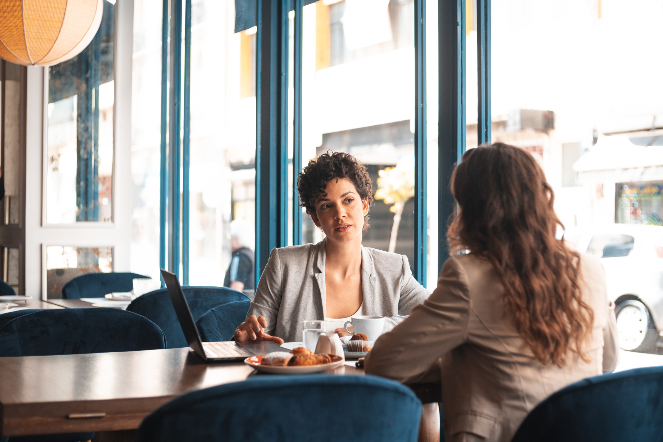 Read about: Two women in business attire meet in a cafe. Learn questions to ask in an informational interview in this article.