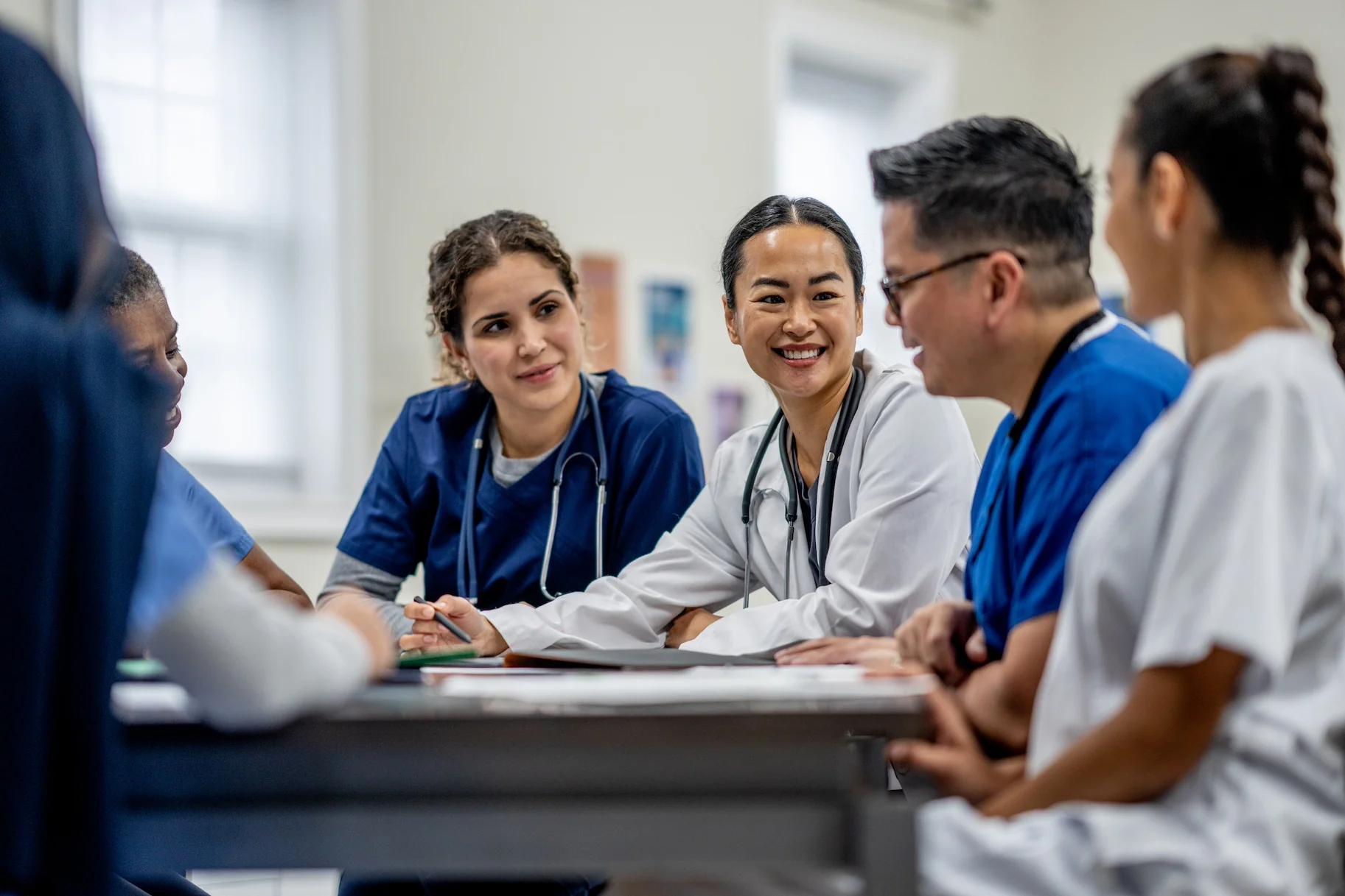Read about: Health care professionals sitting around table collaborating